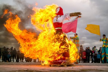 St. Petersburg, Russia - February 22, 2015: Burning of dolls to celebrate the arrival on holiday Maslenitsa. clipart