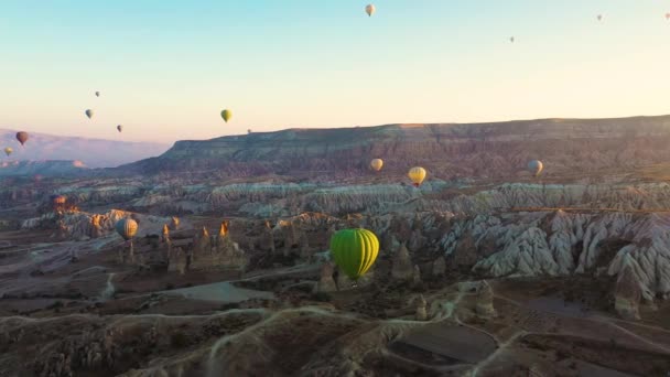 土耳其卡帕多西亚美丽的日出 色彩艳丽的热气球在清澈的清晨天空中 在不同寻常的岩石景观之上飞翔 — 图库视频影像