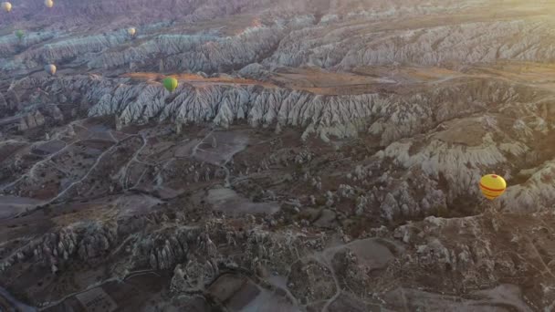 土耳其卡帕多西亚彩色热气球在不同寻常的岩石景观上飞行的空中无人驾驶图像 — 图库视频影像