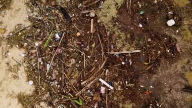 Kumsalda çöp ve çamur yığını, yakın görüş