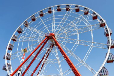Güneşli bir günde lunaparkta dönme dolap dönüyor. Kimse yok.
