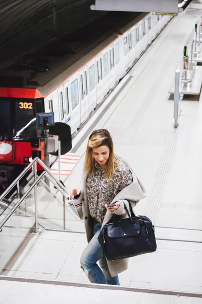 Vrouw met mobiele telefoon op metro — Stockfoto