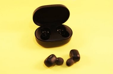 Şarj aleti olan siyah kablosuz kulaklık, modern teknoloji..