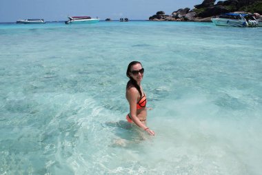 Genç bir kadın bir cennet adasında dinleniyor ve okyanusta yüzüyor..