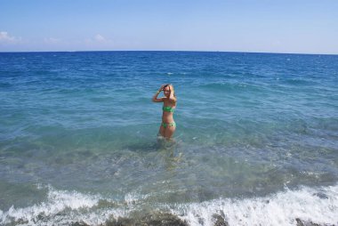 Cennet adasının sahilinde dinlenen genç ve şık bir kadın..