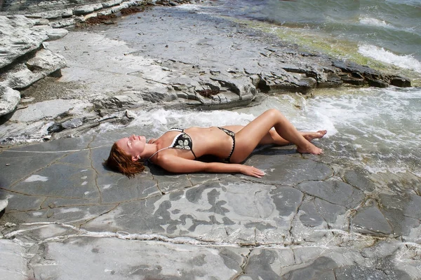 Uma Jovem Está Descansando Enquanto Senta Uma Pedra Junto Oceano — Fotografia de Stock