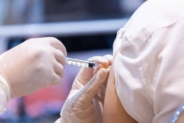 Doktor tarafından tek kullanımlık plastik şırınga ile hastanın koluna enjekte edilen kovid 19 aşısı bağışıklık sistemini inaktif ya da adenovirüs virüsü ile güçlendirir.