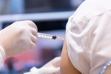 Doktor tarafından tek kullanımlık plastik şırınga ile hastanın koluna enjekte edilen kovid 19 aşısı bağışıklık sistemini inaktif ya da adenovirüs virüsü ile güçlendirir.
