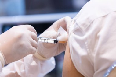 Doktor tarafından tek kullanımlık plastik şırınga ile hastanın koluna enjekte edilen kovid 19 aşısı bağışıklık sistemini inaktif ya da adenovirüs virüsü ile güçlendirir.