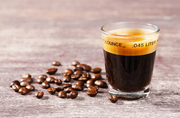 Střílel skla s zrnko kávy espresso — Stock fotografie