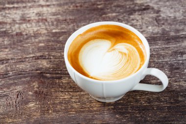 Eski ahşap masada bir fincan kahve.