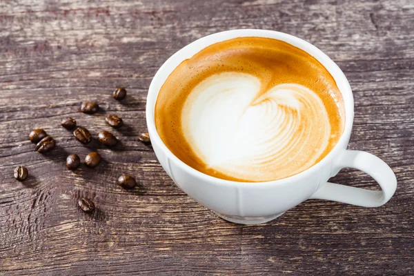 Tasse Kaffee auf altem Holztisch — Stockfoto