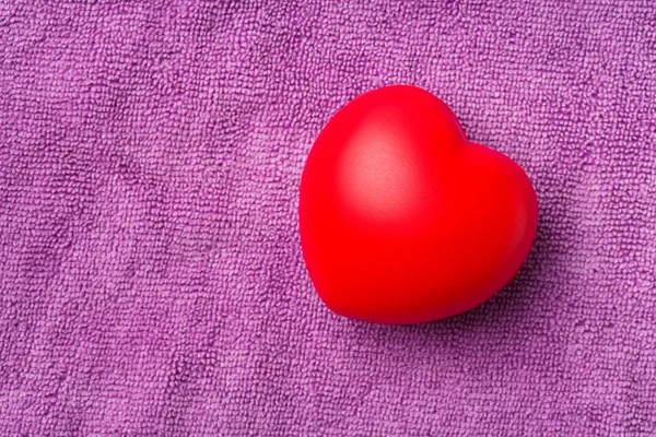 Coração vermelho no pano roxo fundo — Fotografia de Stock