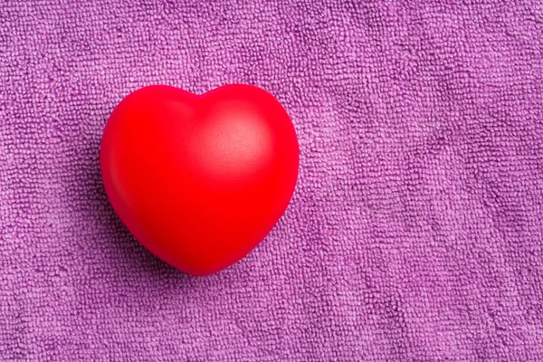 Corazón rojo sobre fondo de tela púrpura —  Fotos de Stock