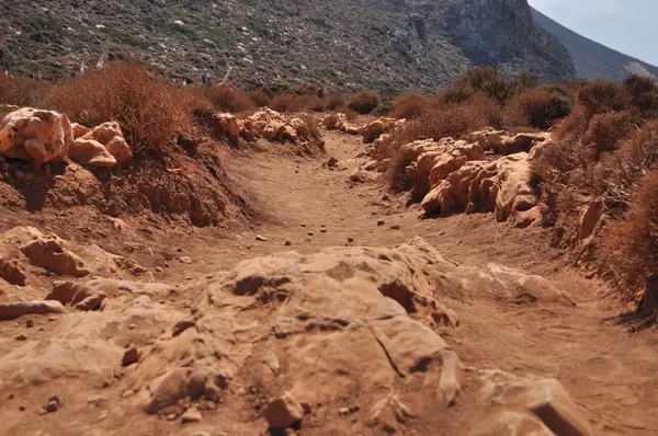 Červené prašné silnici v horách na řeckém ostrově. — Stock fotografie