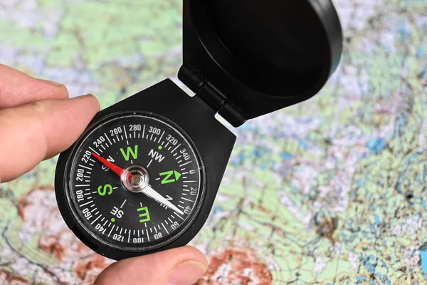 Compass and map. Compass on the background of a topographic map.