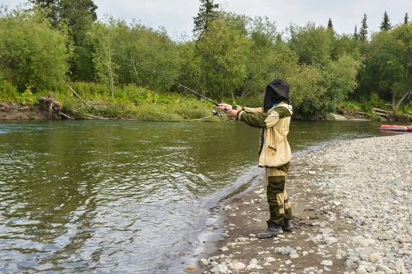 河里的渔夫 一个年轻人带着纺锤在北方的卵石河上钓鱼 — 图库照片
