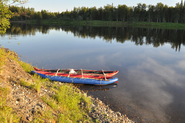 Evening river landscape with a boat on the shore. 