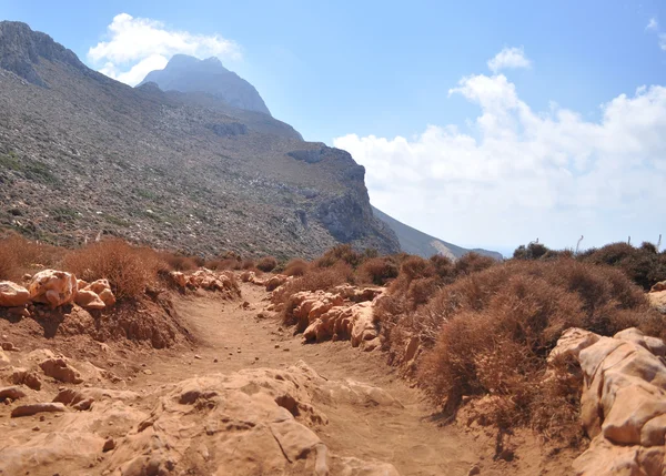 Red dusty road in the mountains on the Greek island. — Stock Photo, Image