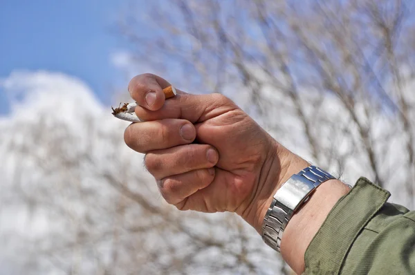 Un cigarrillo roto en su mano. — Foto de Stock