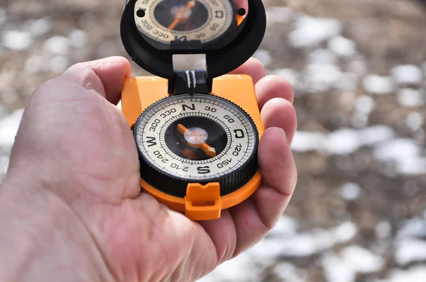 The compass in his hand outdoors. — Stock Photo, Image