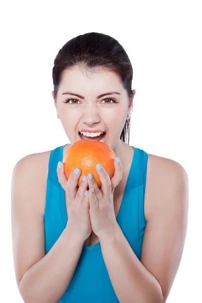 Beautiful girl in sportswear eating fruit — Stock Photo, Image