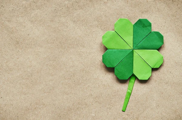 Gröna origami papper shamrock clover blad på eco papper bakgrund. St. Patrick's Day hälsning vykort mall. — Stockfoto