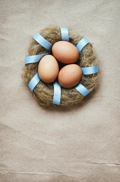 Grinalda de ninho com ovos sobre fundo de papel eco artesanal. Modelo de cartão postal de Páscoa. Espaço para texto, cópia, letras . — Fotografia de Stock