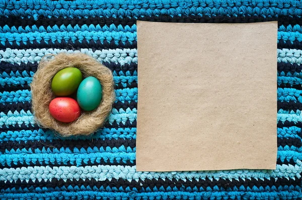 Uova di Pasqua colorate in nido naturale su t-shirt in cotone upcycle blu navy blu cian striped tappeto di sfondo. Spazio per testo, lettering, copia . — Foto Stock