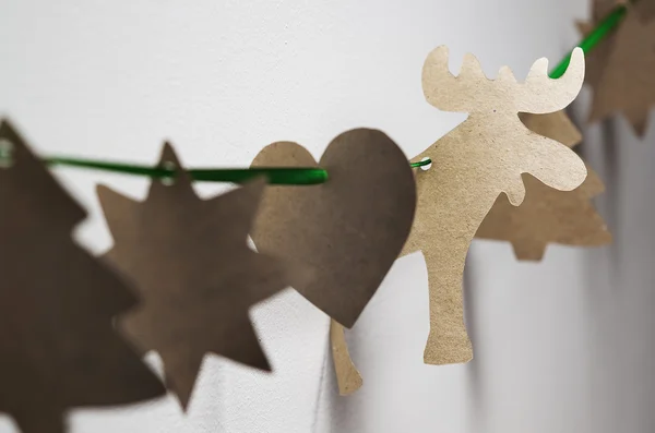Karton ręcznie garland Diy Boże Narodzenie na zielony pasek szmaragd z cienia na białej ścianie backround — Zdjęcie stockowe