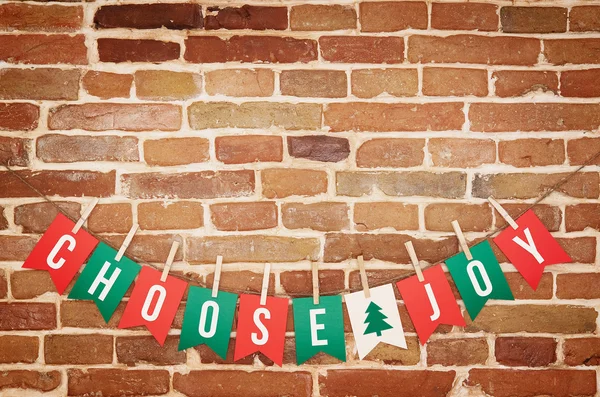 Rot, grün und weiß wählen Freude und Zweig Baum Papier Karte diy Flagge Girlanden Dekoration auf rustikalen Backstein Wand Hintergrund Postkarte. — Stockfoto