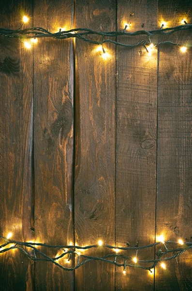 stock image Holiday christmas rough wood background with lights garland.