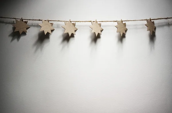 Simples Natal cartolina estrelas guirlanda decoração no fundo da parede branca . — Fotografia de Stock