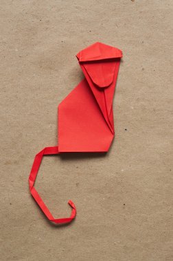 Folded paper origami monkey on red eco background. Vertical postcard template.