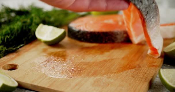 A raw piece of salmon is placed on the cutting board. — Stock Footage A raw piece of salmon is placed on the cutting board. Stock Footage