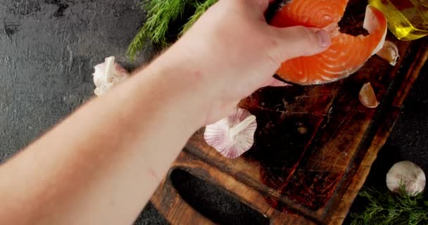 A mans hand puts raw salmon steak on a cutting board. — Stock Footage A mans hand puts raw salmon steak on a cutting board. Video Clip