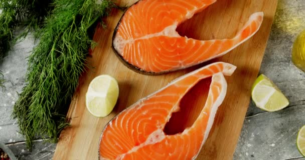 Raw pieces of salmon with lime on the cutting board rotate. — Stock Footage Raw pieces of salmon with lime on the cutting board rotate. Stock Video