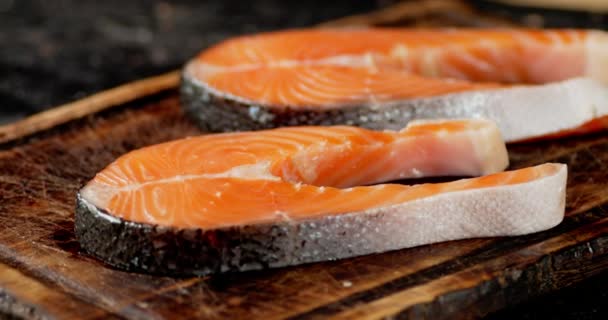 Raw fresh salmon steaks on a wooden cutting board rotate. — Stock Footage Raw fresh salmon steaks on a wooden cutting board rotate. Royalty Free Stock Footage