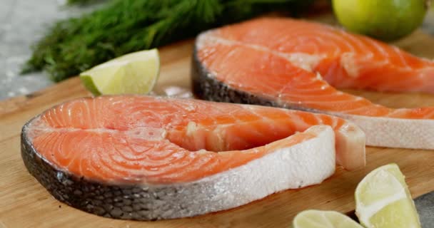 Fresh raw pieces of salmon rotate on wooden cutting board. — Stock Footage Fresh raw pieces of salmon rotate on wooden cutting board. Royalty Free Stock Video