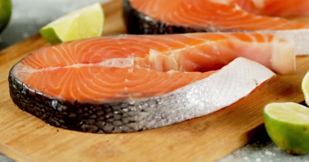 Raw pieces of salmon with lime on the cutting board rotate. — Stock Footage Raw pieces of salmon with lime on the cutting board rotate. Video Clip
