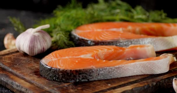 Raw fresh salmon steaks on a wooden cutting board rotate. — Stock Footage Raw fresh salmon steaks on a wooden cutting board rotate. Royalty Free Stock Footage