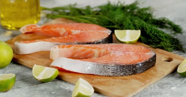 Raw salmon steaks with pieces of lime rotate on the table. — Stock Footage Raw salmon steaks with pieces of lime rotate on the table. Stock Footage