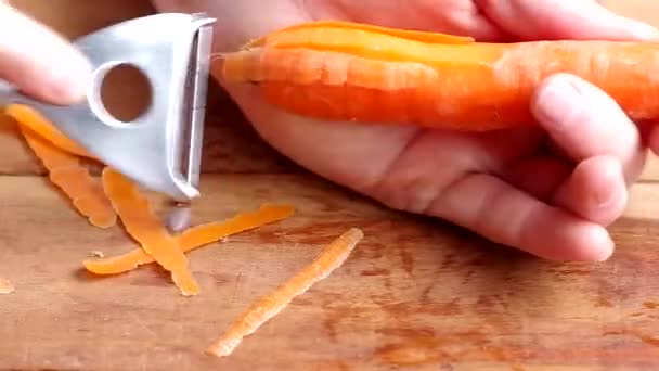 Человек чистит морковь — стоковое видео