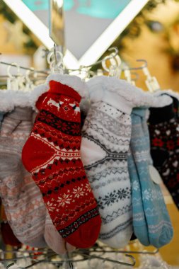 Perakende satışta şenlikli renkli kış çorapları. Soğuk hava alışverişi, mevsimlik dekor, Noel hediyeleri ve tatil moda kavramları için rahat örülmüş ayakkabılar..