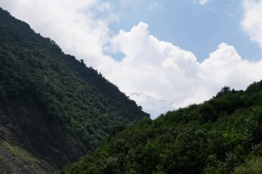Kuzey Kafkasya 'nın dağlarının manzarası. Karmadon Boğazı. Bulutlarda Kazbek Dağı
