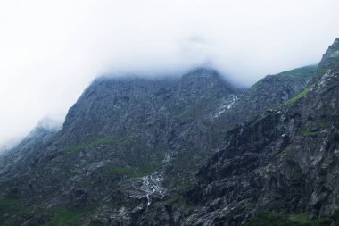 Midagrabindon şelaleleri vadide. Yazın Kuzey Kafkasya 'da dağlar. Bulutlarda dağın tepeleri.