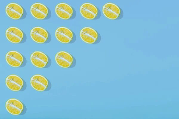 明るい水色の背景に黄色のレモンスライスとトレンディな夏のパターン 最小限の夏のコンセプト 平置き食感 — ストック写真
