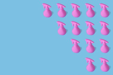 Pembe şişe spreyinden yapılmış desen kozmetik, hijyen, parlak mavi arka planda temizlik sıvısı. Kopyalama alanı olan ambalaj için yaratıcı asgari tasarım.