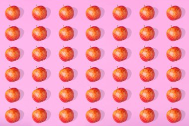 Pembe pastel arka planda taze elmanın olağanüstü deseni. Minimalist izometrik gıda konsepti. Düz yatıyordu