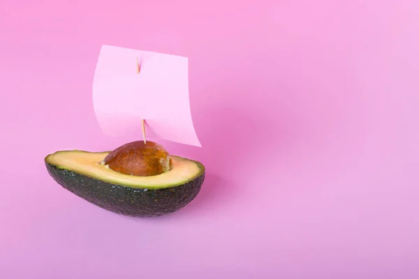 Połowa Świeżych Owoców Awokado Jacht Lub Żaglówka Żaglami Jasnoróżowym Tle — Zdjęcie stockowe